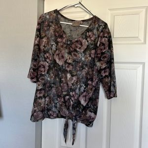 Soft, floral pattern v-neck top with 3/4 length sleeves and bottom tie accent.